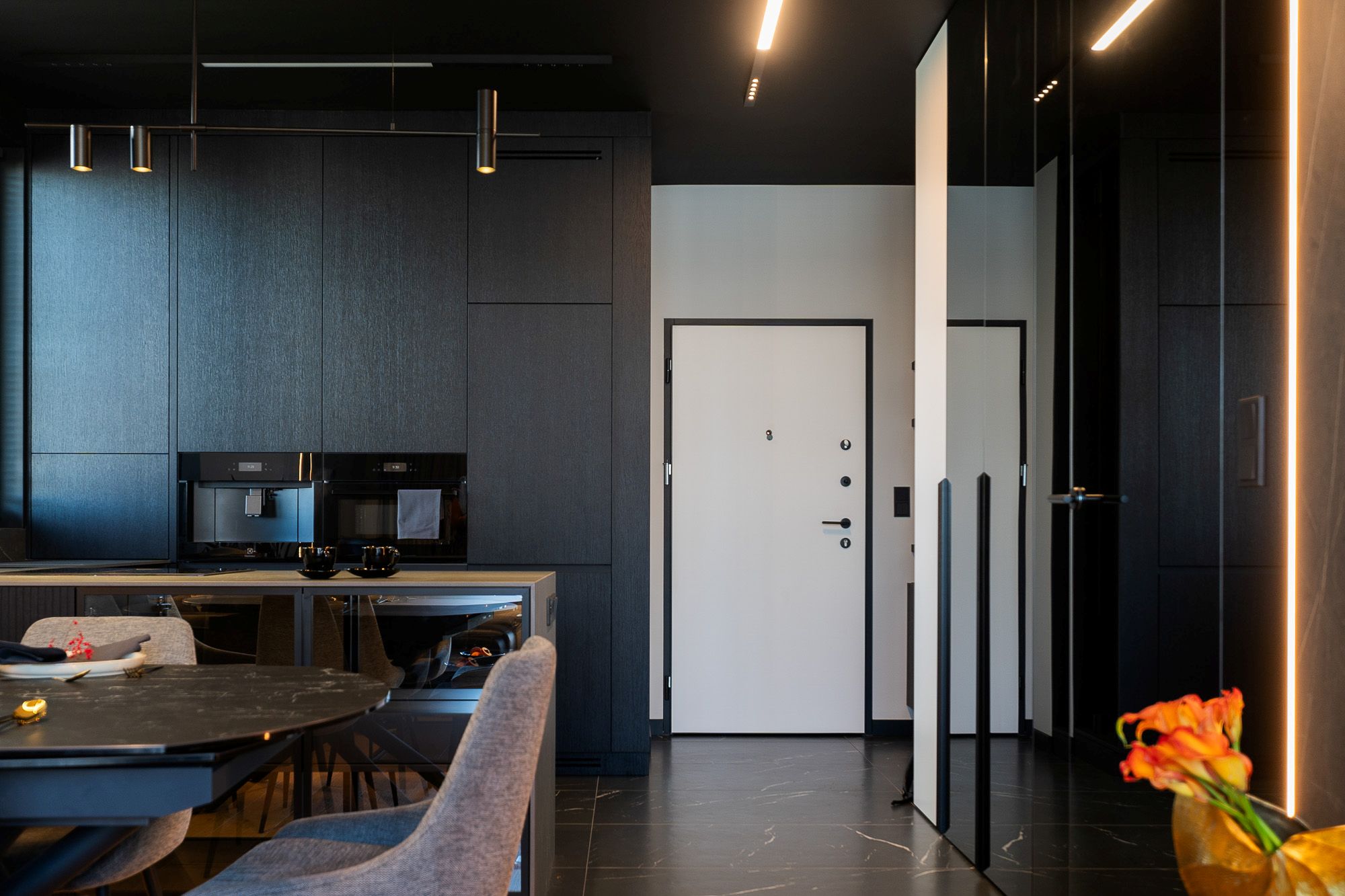 Aranżacja białych drzwi wejściowych z ciemną podłogą.